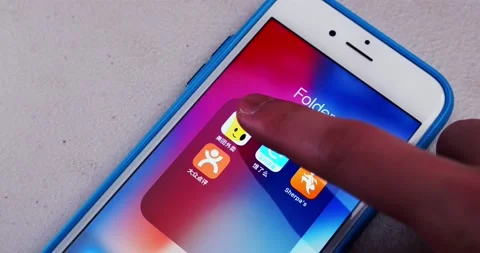 Man opens Meituan Waimai app and watches its opening screen on an iPhone Stock Footage 175219653