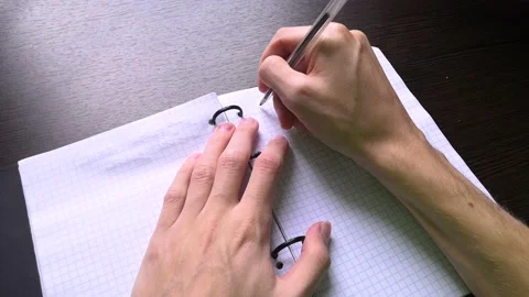 The man opens a notebook and begins to write down his ideas in it with a pen Stock Footage 160555902