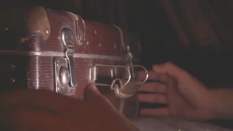 The man opens an old battered brown suitcase. Stock Footage 137738305