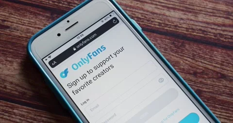 Man opens OnlyFans website on an iPhone on shabby chic table Stock Footage 207548894