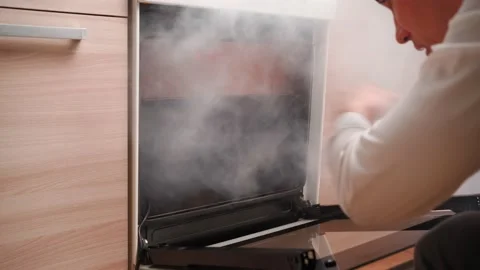 Man Opens an Oven Full Smoke in Kitchen. Bachelor Ruined Dinner with Burnt Food Stock-Footage 170087747