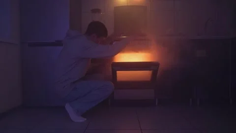 A man opens the oven as thick smoke escapes, engulfing the dimly lit kitchen. He Stock Footage 305449841