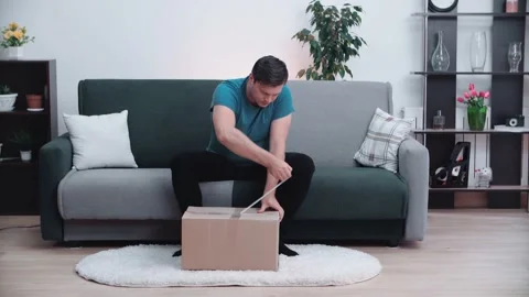 The man opens the package and is very happy with what is in it. Stock Footage 145367629