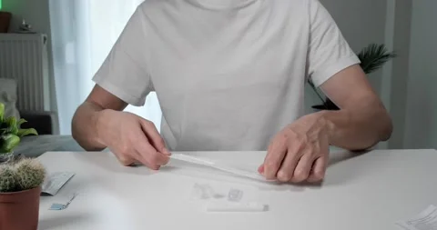 Man opens package with nasal swab to take Covid-19 self test at home. Stock Footage 155074296