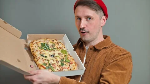 A man opens a pizza box to reveal a large pizza topped with various ingredients. Видео 337642695