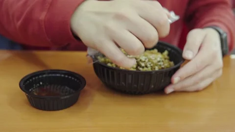 A man opens a plastic lunch plate with asian dish: rice with chicken curry. A Stock Footage 164678663