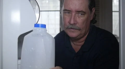 Man opens refrigerator to get milk Stock Footage 55543909