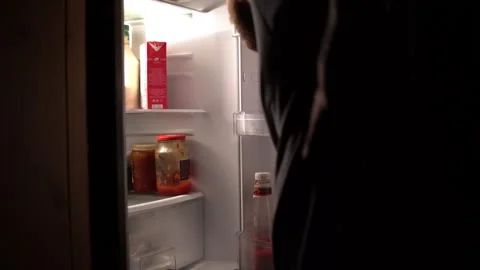 A man opens the refrigerator at night and takes a carton of milk Stock Footage 139158957