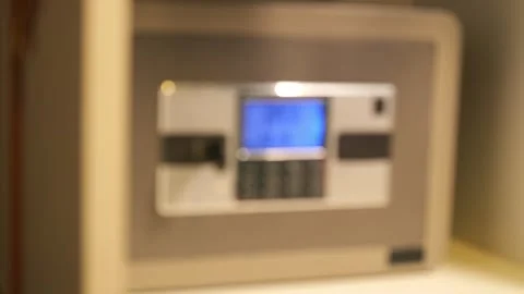 A man opens a safe and puts Chinese cash in it Stock Footage 277864523