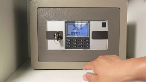 A man opens a safe and puts Chinese cash in it 스톡 동영상 277934557