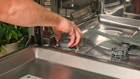 Man opens salt compartment of dishwasher, pours salt into through funnel Stock Footage 244638092