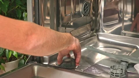 Man opens salt compartment of dishwasher, pours salt into through funnel Stock Footage 244804477