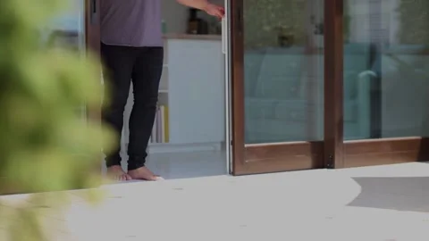 Man opens sliding doors and walks into the patio Stock Footage 161594041