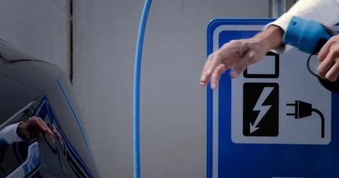 Man opens the socket of his electric black car to connect the recharge plug. Alt Stock Footage 128946146