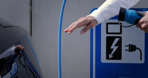 Man opens the socket of his electric black car to connect the recharge plug. Alt Stock Footage 128946148