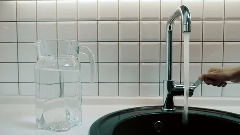 Man opens tap and flow of water pours into sink indoors. Stock Footage 82235625