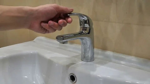 Man opens the tap with water Stock Footage 77413564