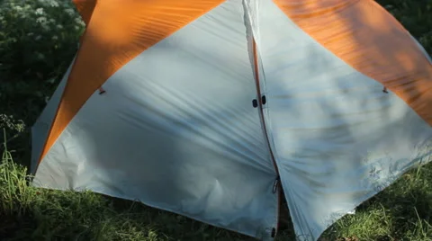 The man opens the tent and starts to talk on the phone in the forest Stock Footage 64309983