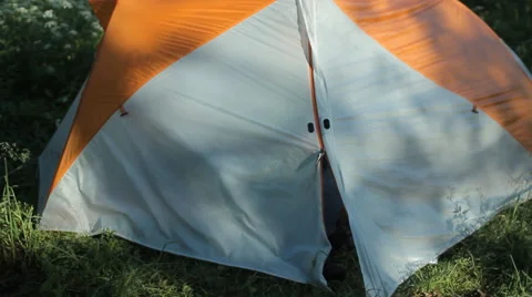 The man opens the tent, making some touch on the phone and close the tent Stock Footage 64311361