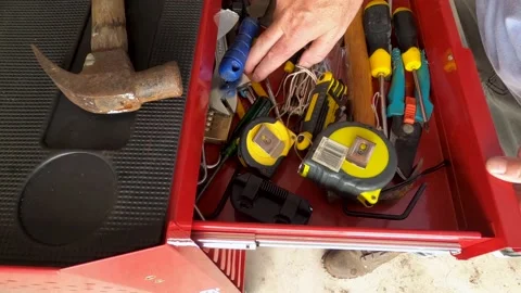 A man opens toolbox drawers, searching for something. View from top left. Video stock 188668740