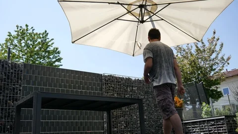 A man opens an umbrella from the sun on the terrace Stock Footage 89673341
