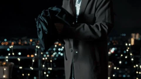 Man opens, unfolds, closes, assembles black sun umbrella on camera Stock Footage 312077643