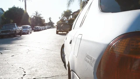 Man opens vehicle door while leaving compact car on neighborhood street Video stock 89190524