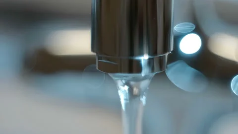 A man opens water in a shiny chrome tap, water flows, then closes the water Stock Footage 130068519