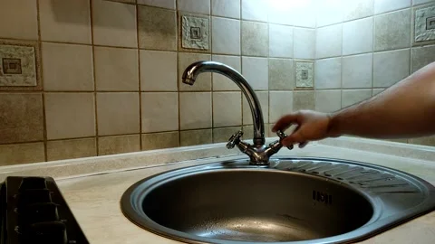 Man opens water tap, and then closes it back. Stock Footage 143163341
