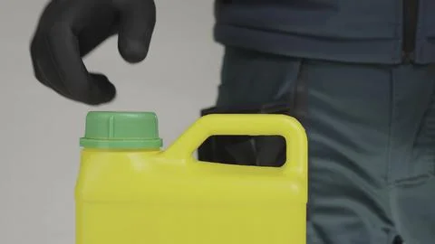A man opens a yellow container with a green lid, revealing its contents Stock Photos