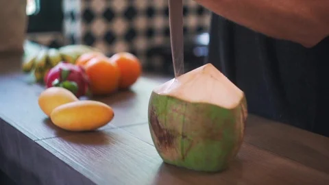 Man Opens Young  Coconut in Kitchen with Coconut Water in Slow Motion. Stock Footage 114664263