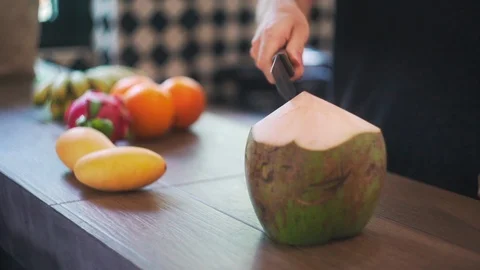 Man Opens Young Green Big Coconut in Kitchen with Coconut Water in Slow Motion. Stock Footage 114664490