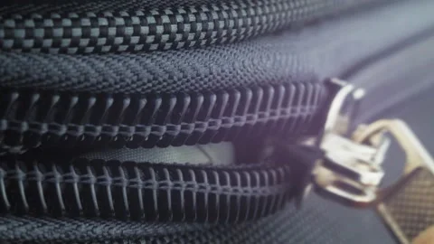 The man opens the zipper of the suitcase. Macro video of a lightning dog Stock Footage 220085422