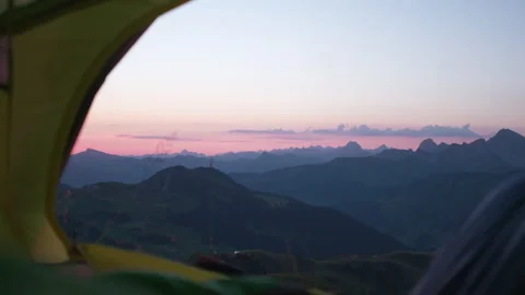 A man opens the zipper of the  tent from the inside. Mountain view at sunrise Stock Footage 266422118