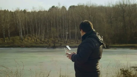 Man operates a drone on a sunny spring day Stock Footage 73345058