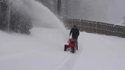 Man operates snow blower during heavy snowfall Video stock 147950990