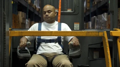 Man operating and reversing machinery in warehouse aisle by stock. 動画素材 88027430