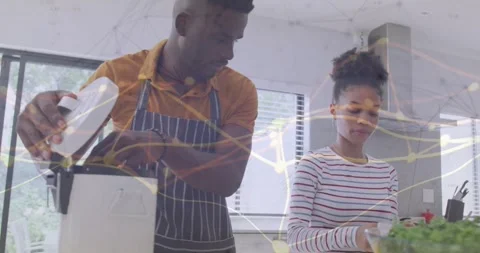 Man operating blender opening lid adding herb while woman inspecting, overlay Stock Footage 331634543