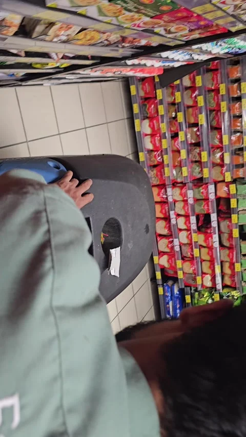 Man operating a blue floor cleaning machine in a supermarket aisle with shelves 스톡 동영상 311589376