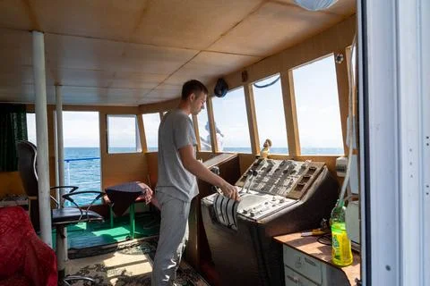Man Operating Boat Controls in Cholpon-Ata, Kyrgyzstan 库存照片