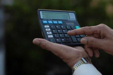 Man operating calculator standing on rooftop outdoor. Covid, Lock down and Ho Stock Photos