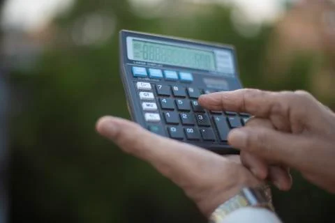 Man operating calculator standing on rooftop outdoor. Covid, Lock down and Ho Stock Photos