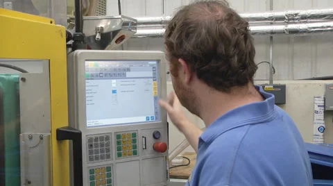 Man operating CNC controls on machinery Stock Footage 46632307