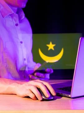 Man operating computer with holographic green flag featuring crescent and sta Stock Photos