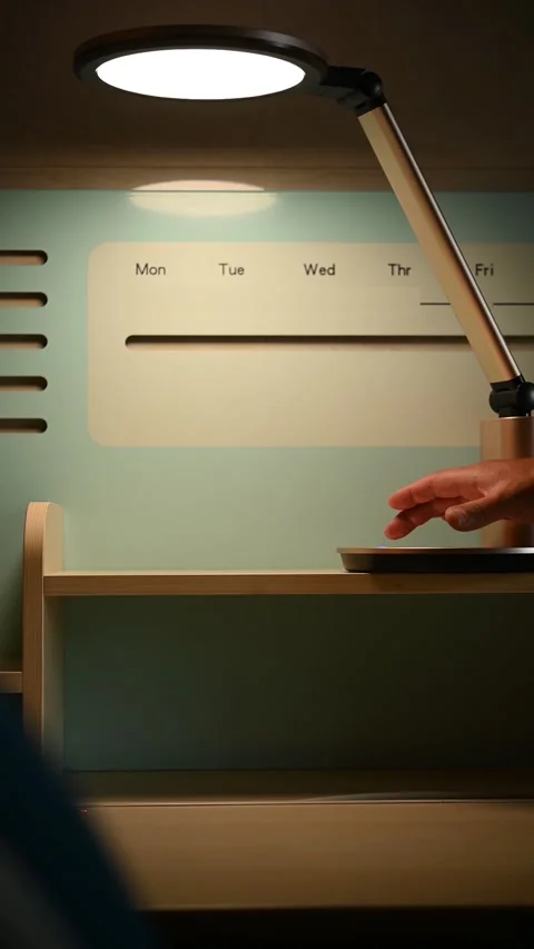 Man operating a desk lamp and setting up the brightness vertical composition Stock Footage 220345304