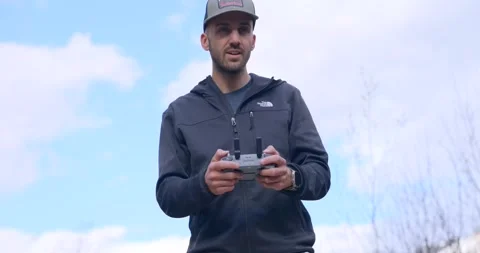 Man operating DJI drone remote controller outdoors. Close up Stock Footage 336355927