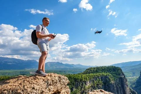 Man operating drone on cliff Stock Photos