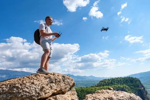 Man operating drone on cliff Stock Photos