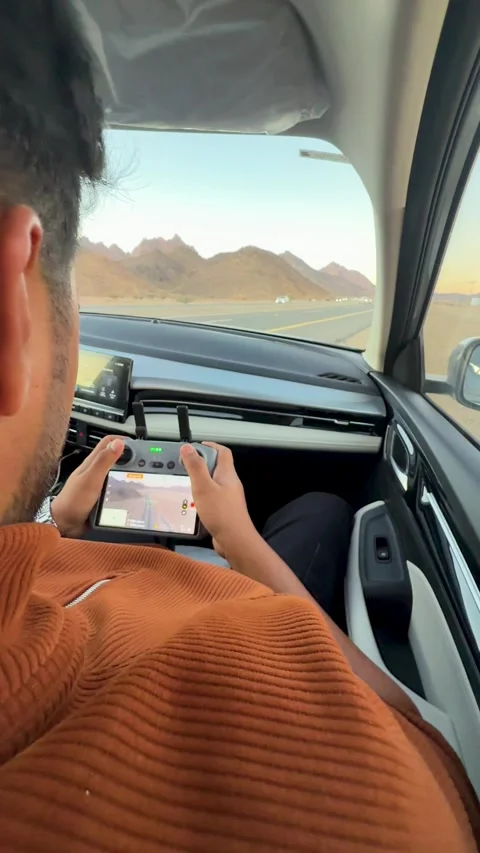 Man Operating Drone Controller Inside Car on Desert Highway 库存影片 337482026