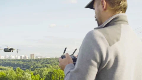 Man operating a drone quadrocopter with camera Stock-Footage 79953196